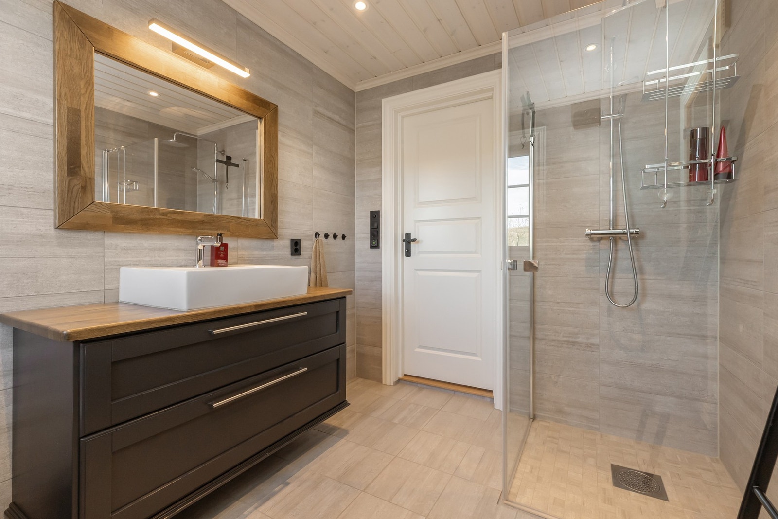 Begge bad kommer i helflisede veggoverfalter og trepanel i himling Galleribilde