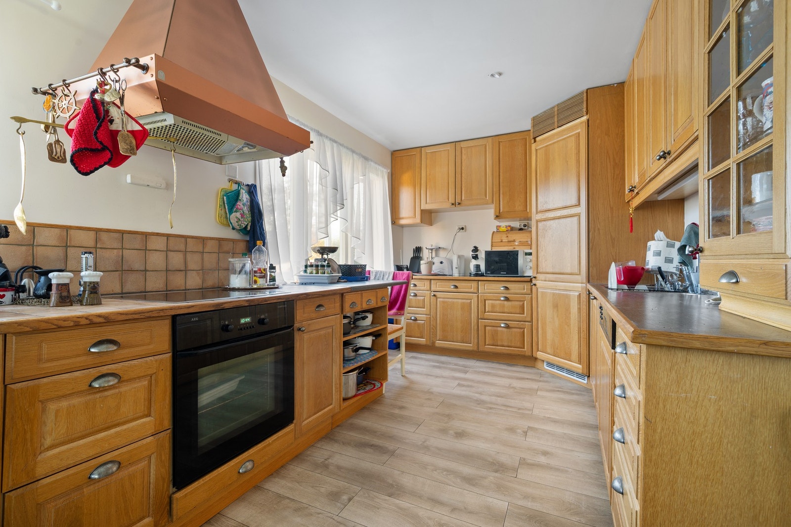 Kjøkkenet har innredning med profilerte eikefronter og benkeplate av laminat Galleribilde