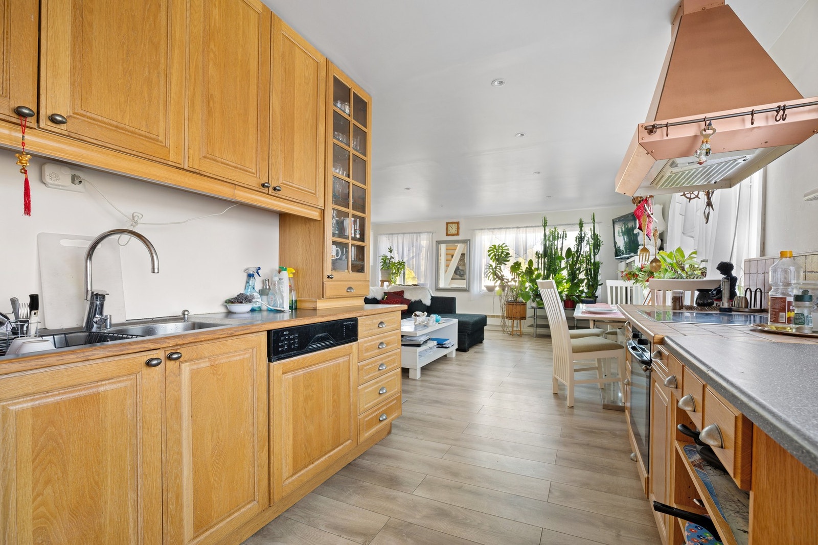 Innredning på flere vegger og takhøye overskap gjør kjøkkenet romslig og funksjonelt Galleribilde