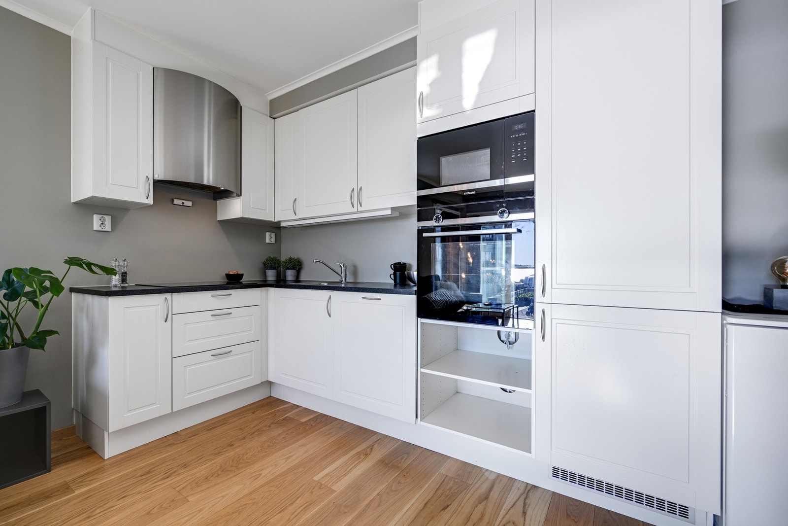 Pent og lyst kjøkken med integrerte hvitevarer Galleribilde