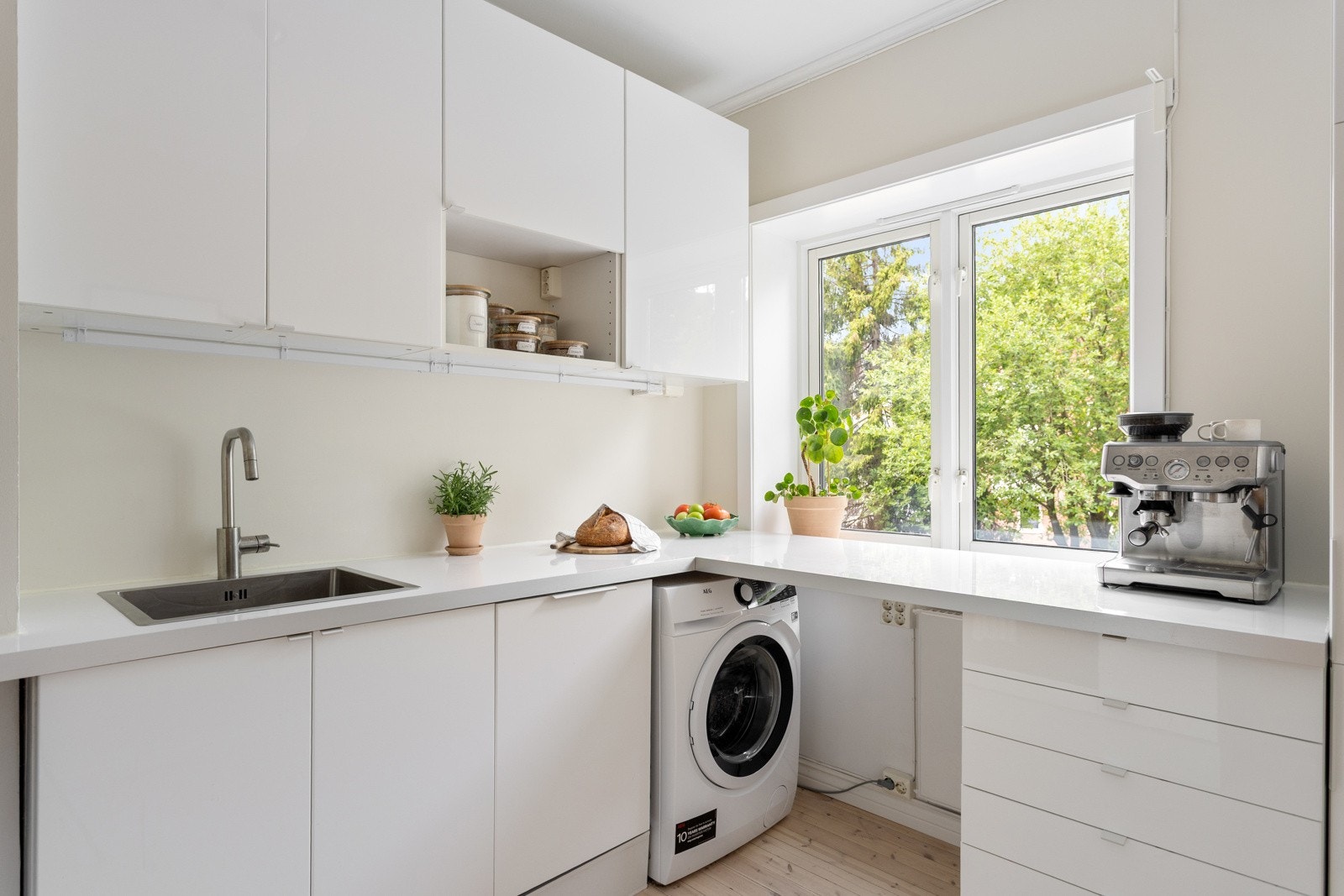 Delikat og moderne kjøkken med vindu ut mot bakgård. Galleribilde