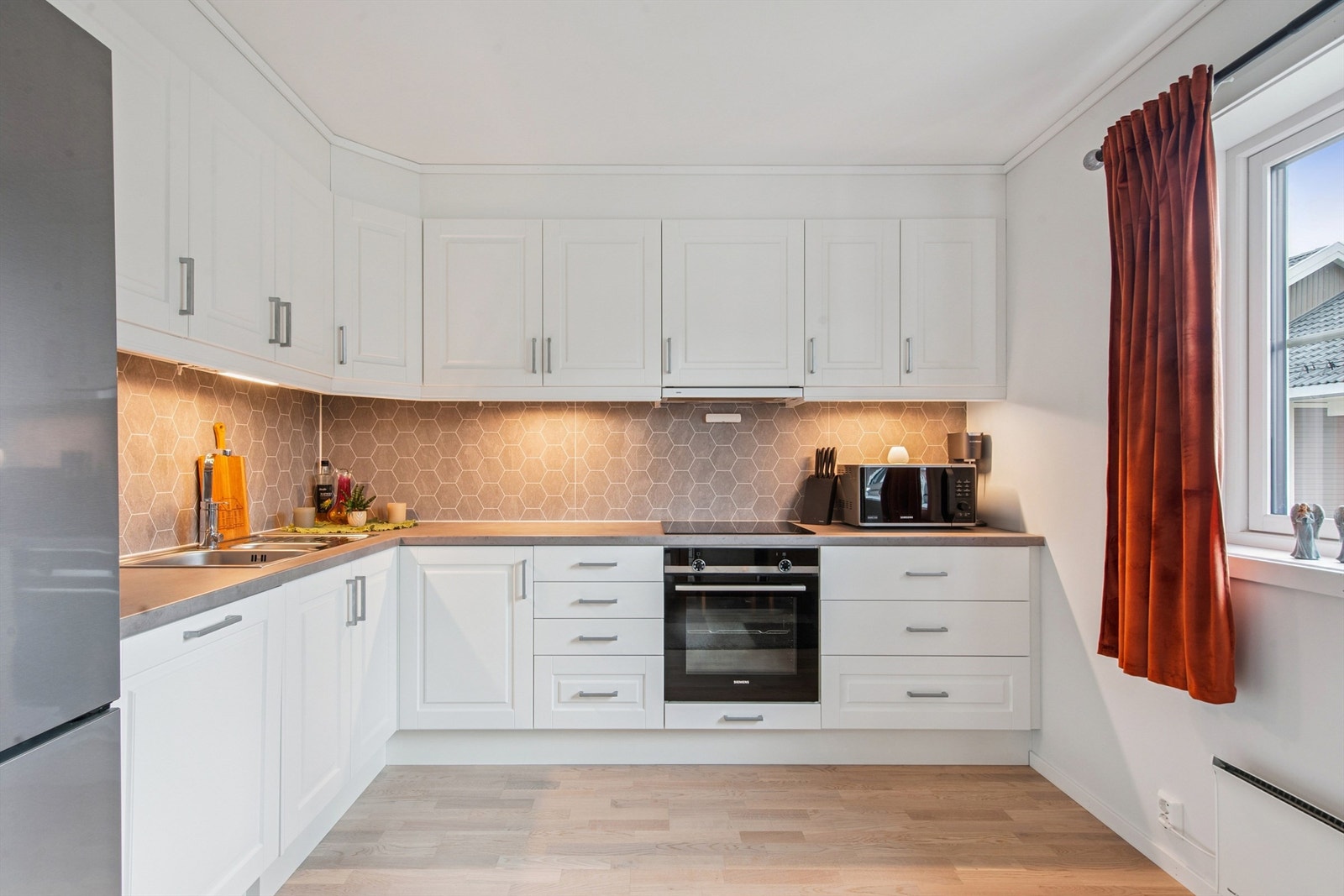 Kjøkkeninnredningen byr på rikelig med skap- og benkeplass. Galleribilde