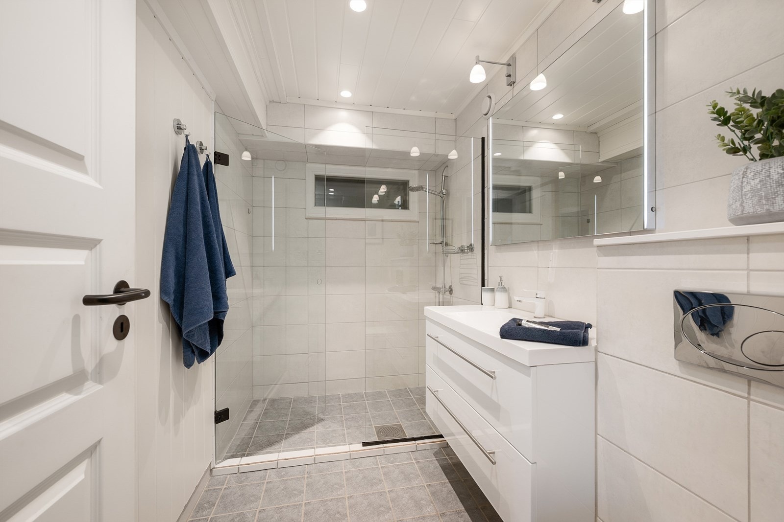 Boligens andre bad ligger i sokkeletasjen. Lyst og delikat med dusjnisje, baderomsinnredning og wc. Galleribilde