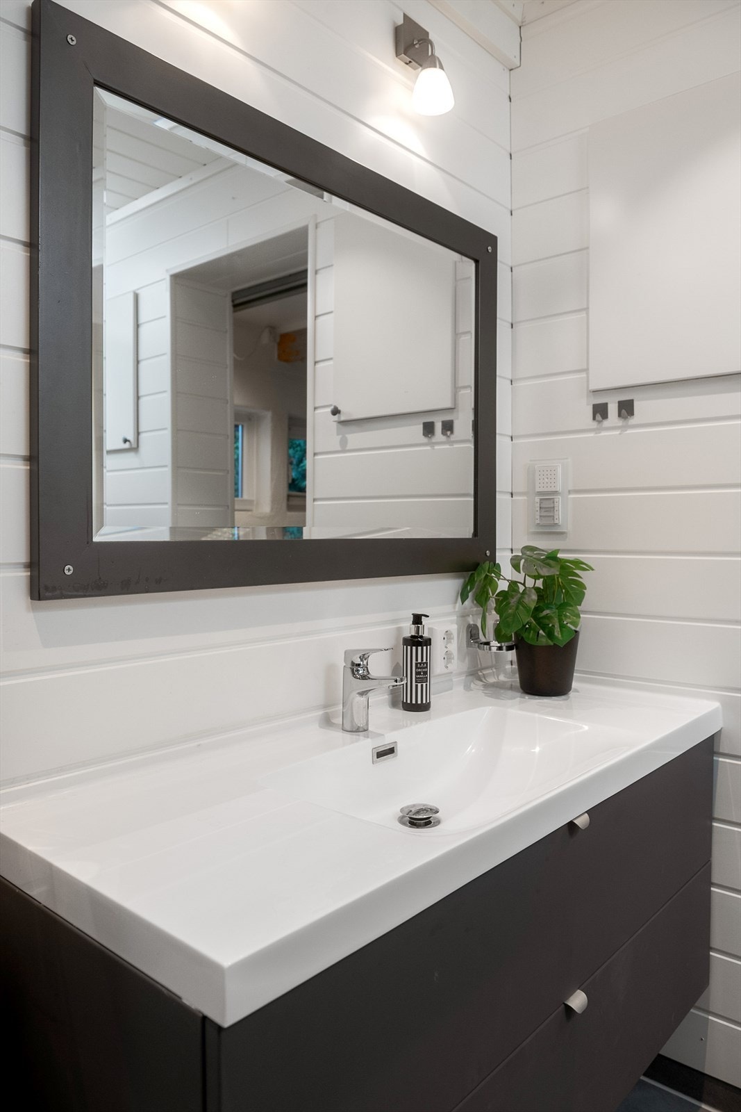 Baderomsinnrednigen har glatte, svarte overflater. Skuffer for oppbevaring. Galleribilde