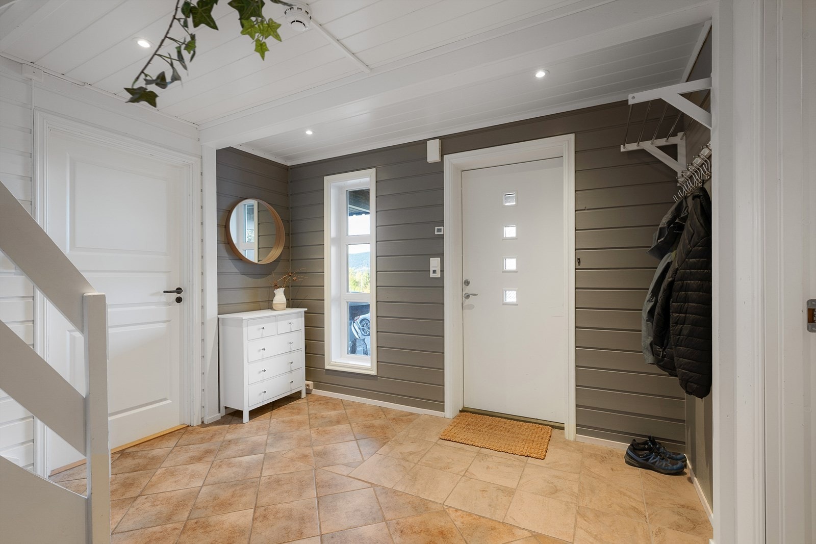 Romslig hall med trapp opp til hovedetasjen. Fra gangen er det adkomst til 2 av soverommene og til ett av badene i boligen. Galleribilde