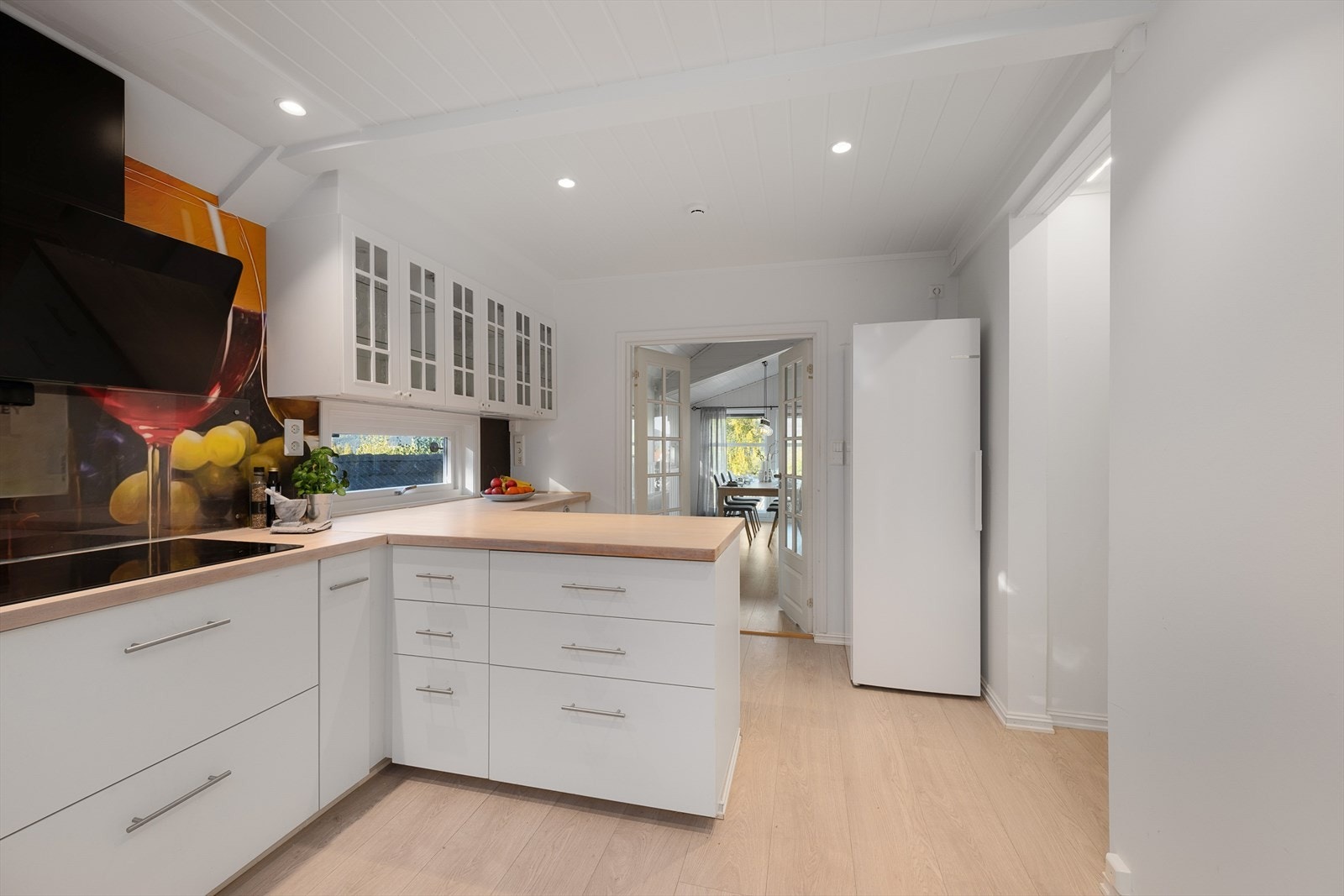 Spotter i taket på kjøkkenet. Alle overflater i lyse og tidløse fargtoner. Galleribilde