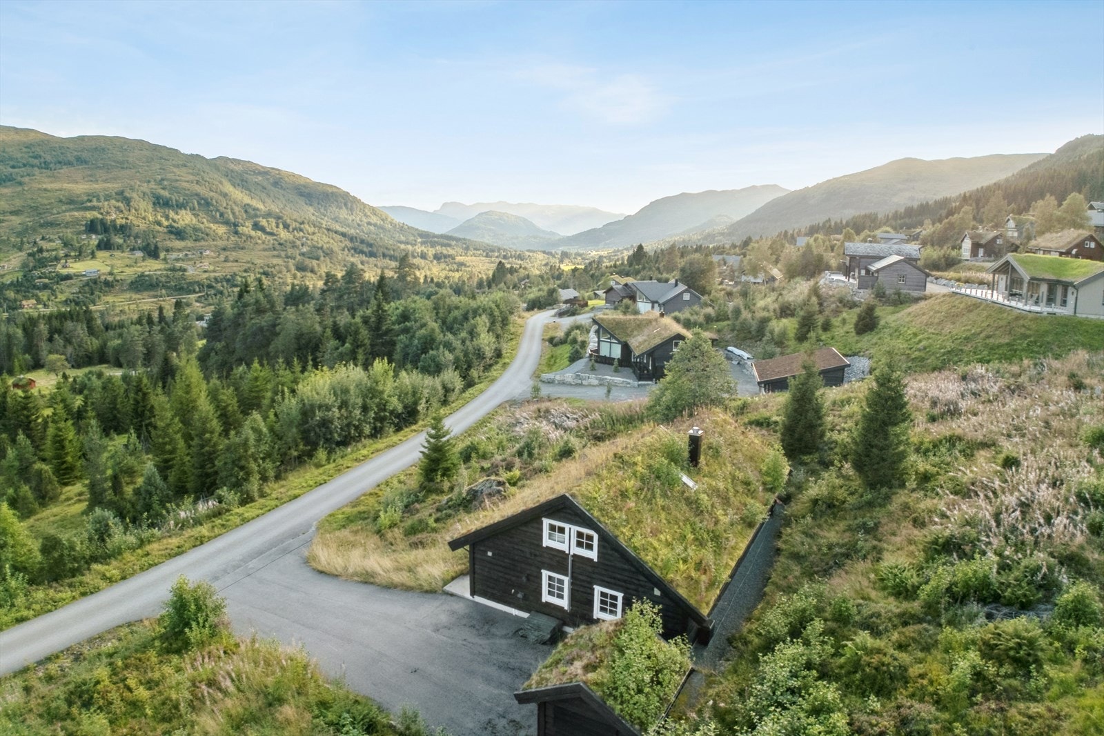 Hytta ligg fint og luftig til nede i feltet Galleribilde
