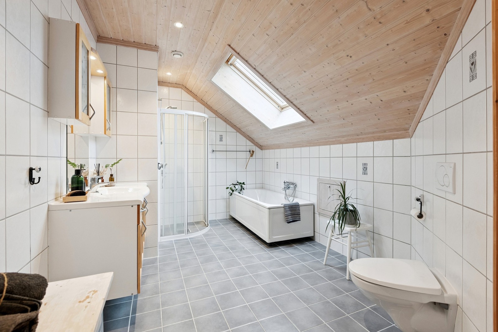 Bad på loftet med dusj, badekar, servant og vegghengt toalett. Galleribilde