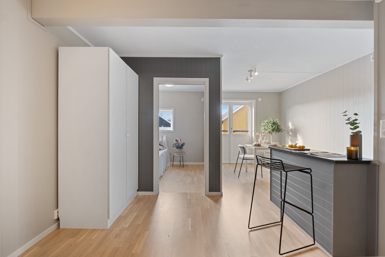 Inngang til lekker stue i fine farger og med god naturlig belysning fra vinduer og balkongdør. Galleribilde