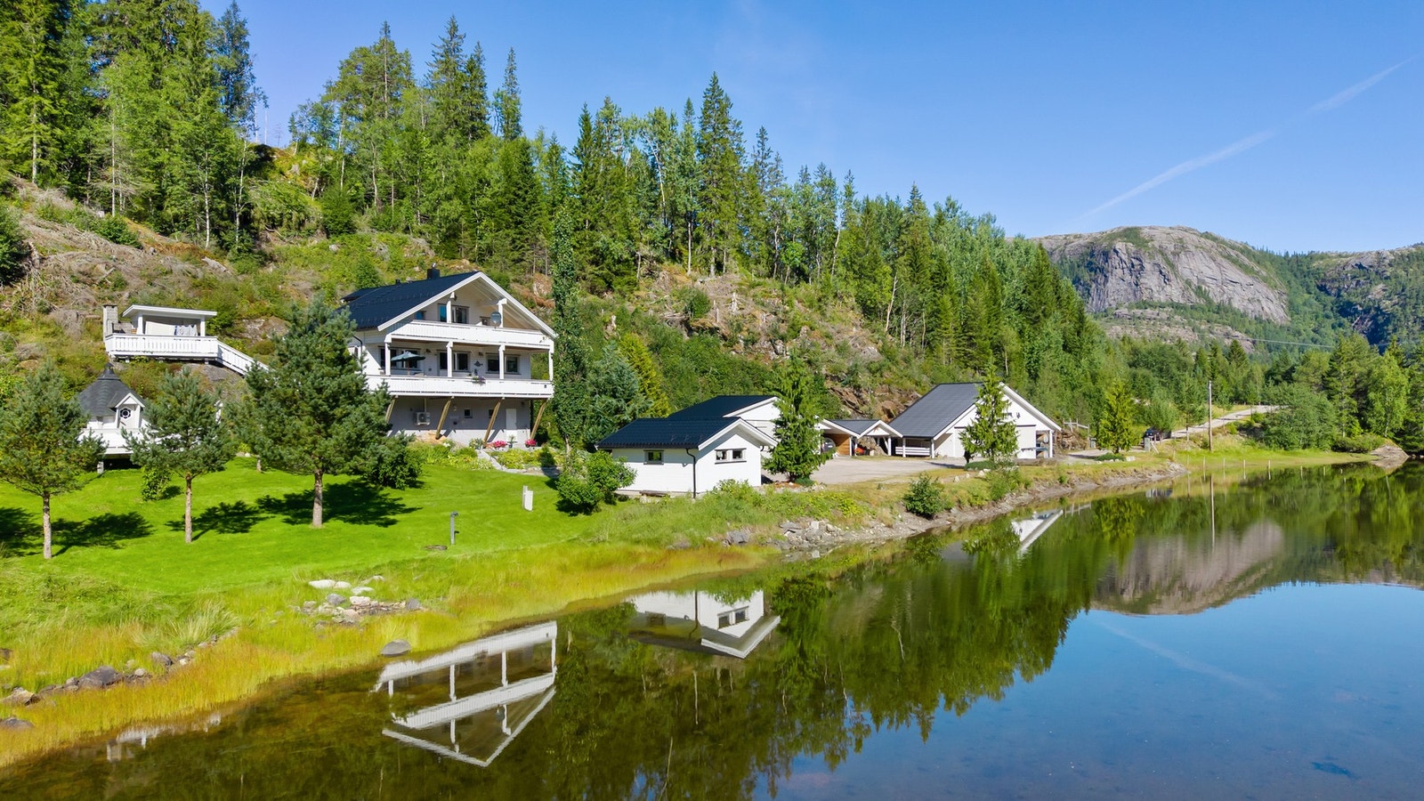 Idyllisk tun med parkmessig hage og velholdt bygningsmasse. Galleribilde