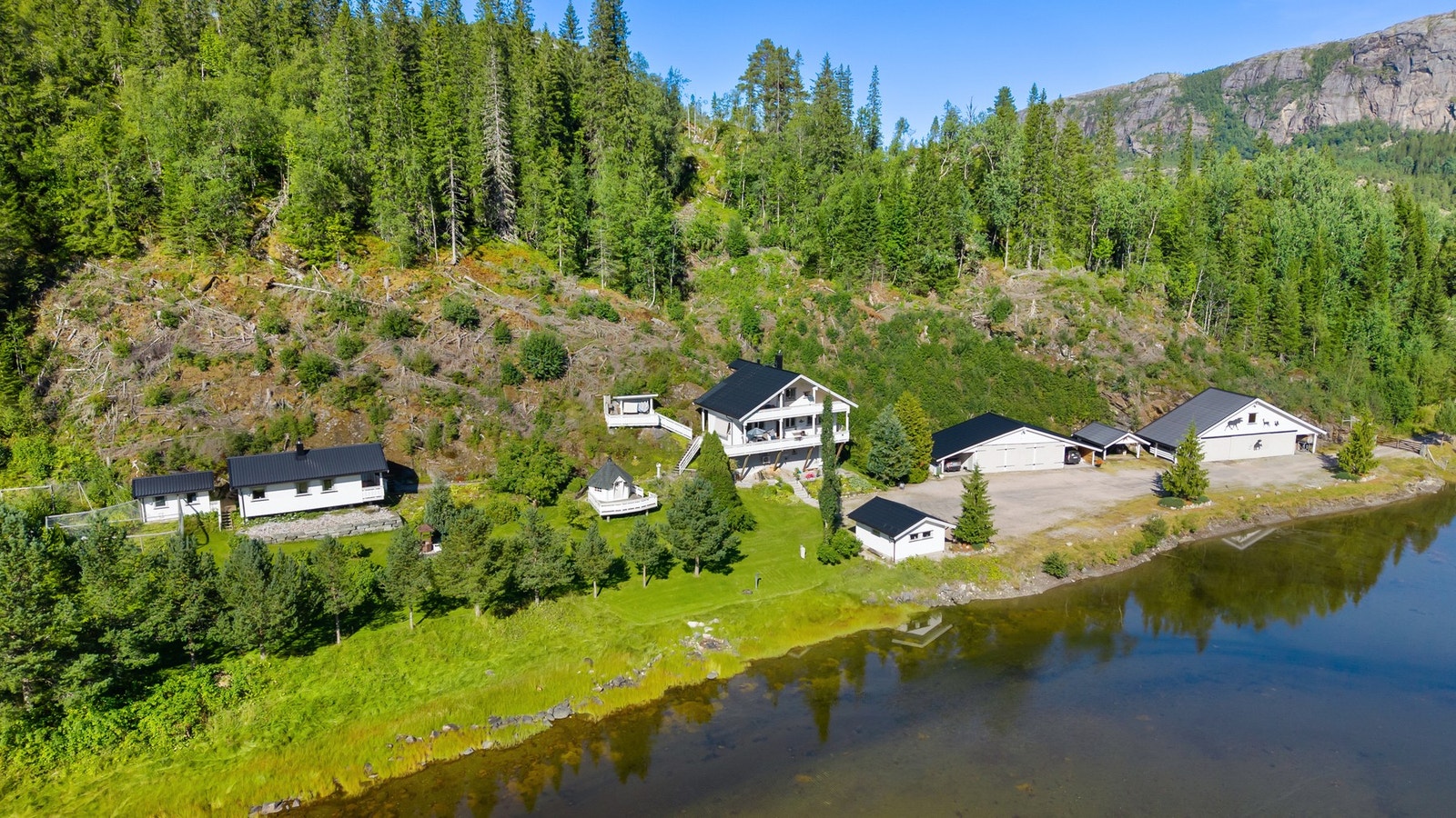 Idyllisk tun med parkmessig hage og velholdt bygningsmasse. Galleribilde