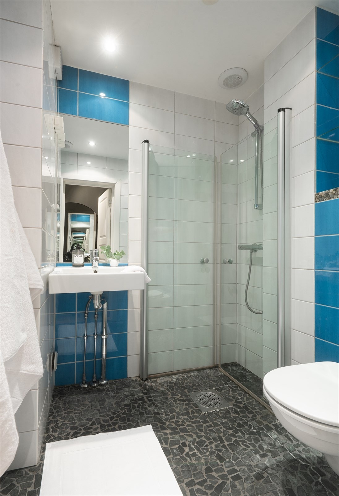 Lyst bad med flislagte overflater. Gulvet er belagt med natursteinsfliser og har elektriske varmekabler. Galleribilde