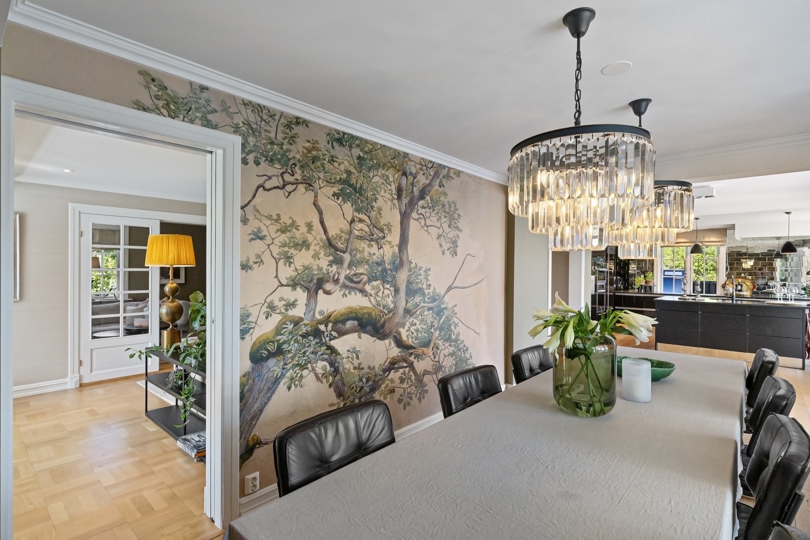 Stuen i første etasje har en sosial plassering med to døråpninger inn til kjøkkenet og spisestuen.