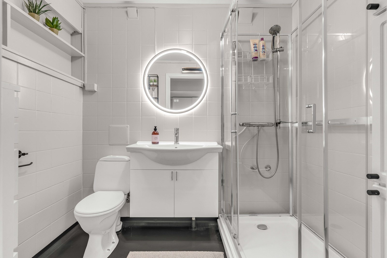 Badet er lyst og pent med toalett, servantmøbel, speil og dusjkabinett. Galleribilde
