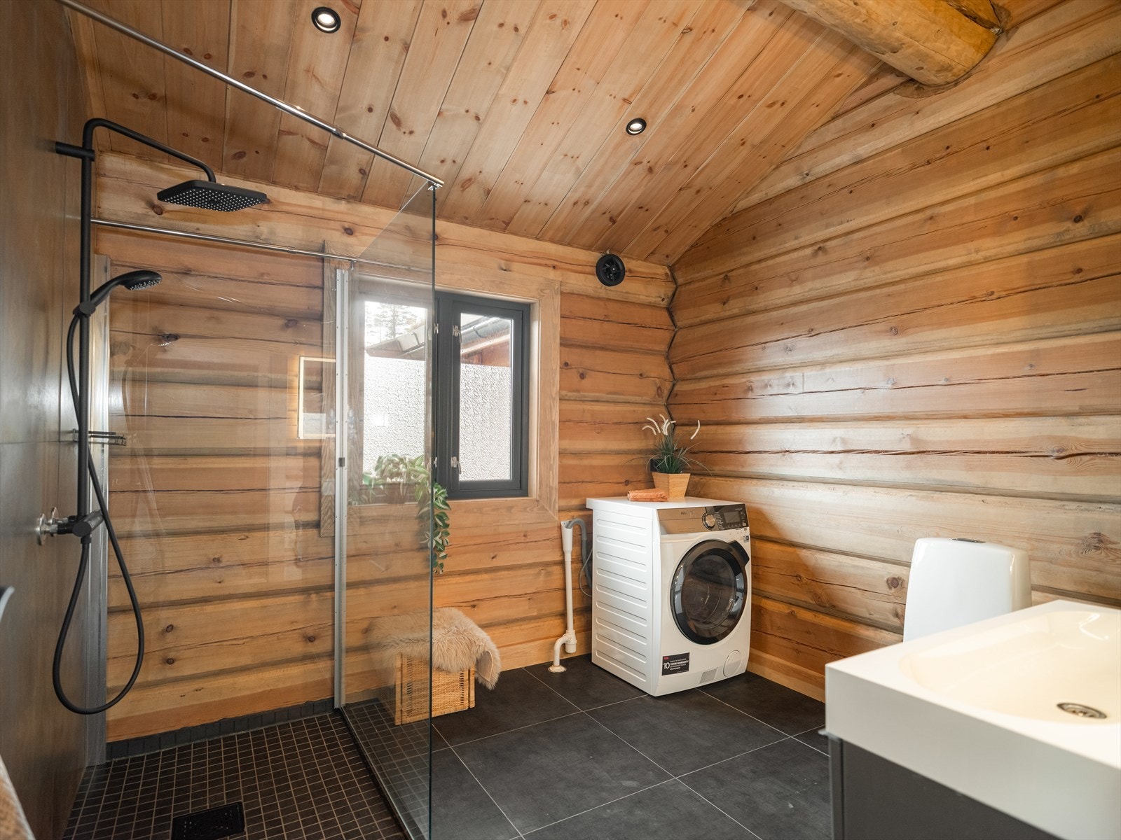 Hovedbadet har fliser på gulv med varmekabler, og opplegg for vaskemaskin. Galleribilde