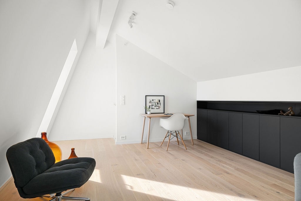 Den øverste etasjen er et lyst og moderne oppholdsrom med skråtak og store vinduer som gir flott utsikt. Galleribilde