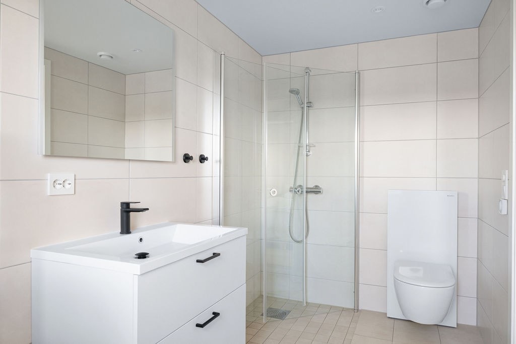 Flislagte overflater, spotter i tak, vannbåren gulvvarme og vindu gir en lys og komfortabel opplevelse. Galleribilde