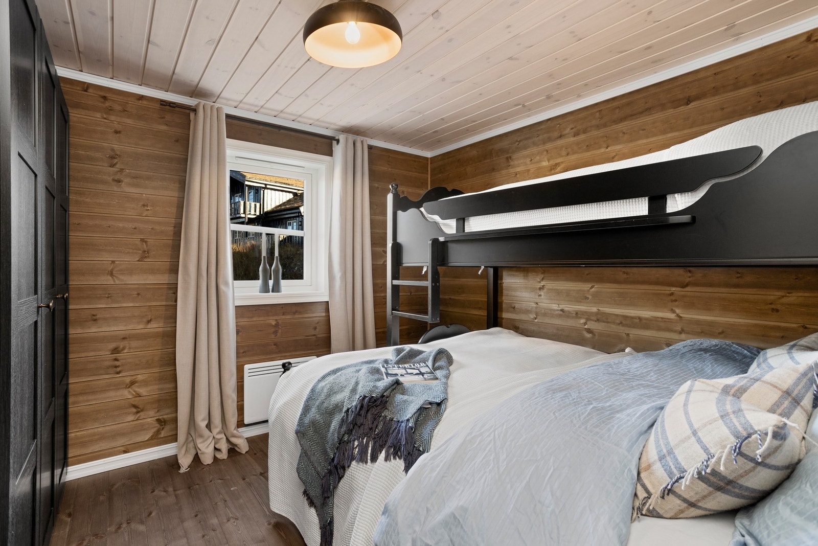 Soverom II er innredet med familiekøye. Begge rommene har lune materialvalg på overflater Galleribilde