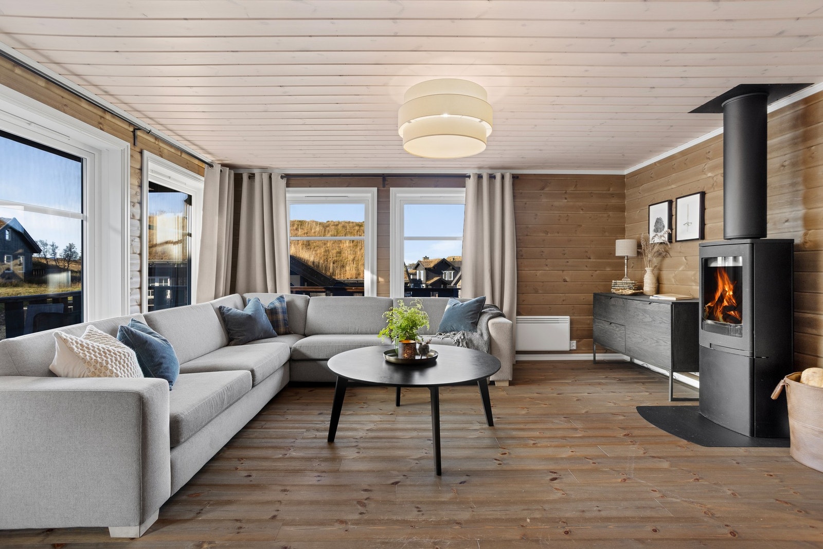 Rommet har store vindusflater som slipper lyset og naturen inn Galleribilde