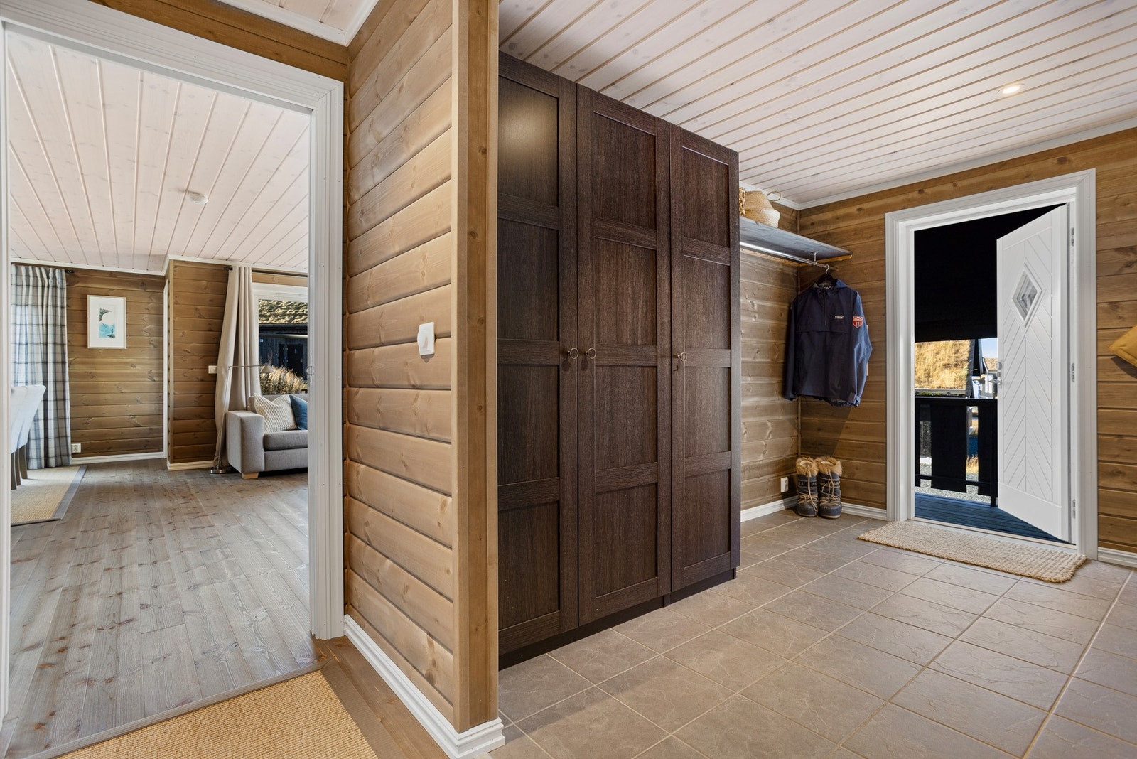 Hytta har en romslig og innbyende entré. Her er det god plass til oppbevaring av yttertøy og sko i blant annet garderobeskap. Flislagt gulv med varmekabler gir en lun velkomst Galleribilde