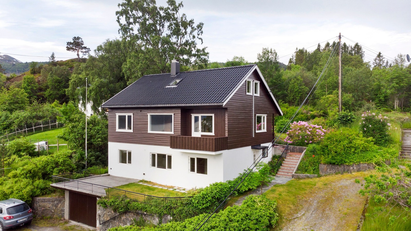 Pent tillagde utearealer med diverse beplantning og hekk. Garasje i betong Galleribilde