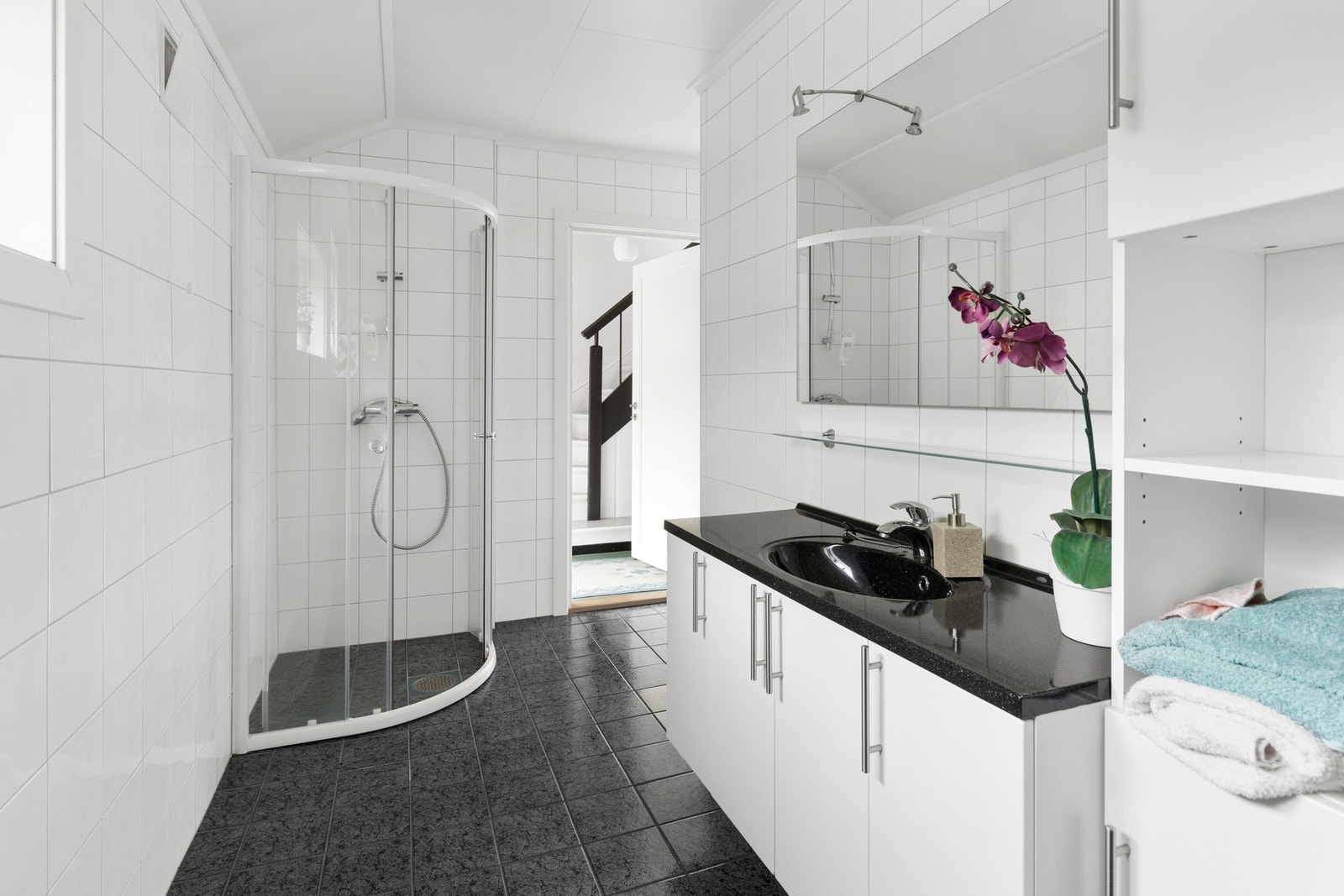 Bad/vaskerom i 1.etg renovert i 2007/2008 i helfliset utførelse. Av utstyr er det montert gulvvarme, opplegg for vaskemaskin, skyllekum, wc, dusjnisje med glassdør og baderomsinnredning med helstøpt servantplate Galleribilde