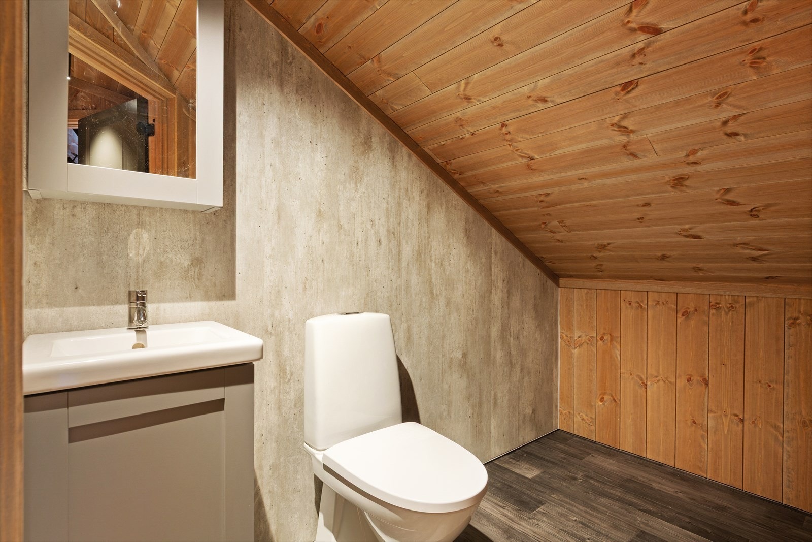 Toalettrom på hems med wc, servantskap med servant og tilhørende skap med speil. Galleribilde