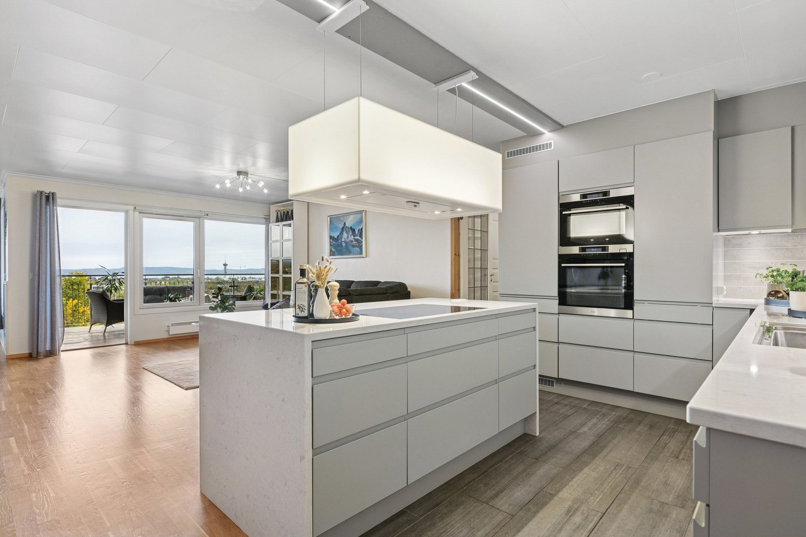 Et tidløst kjøkken med det lille ekstra, bla. benkeplate av stein og en tøff fritthengende ventilator. Galleribilde