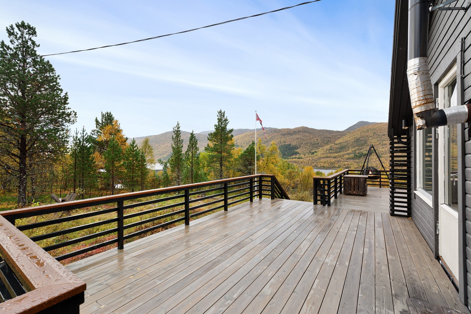 Terrassen strekker seg rundt boligen slik at man enkelt kan flytte seg etter solen Galleribilde