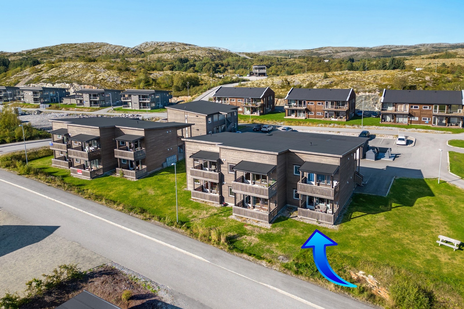 Plenlagt fellesareal. Asfaltert område ved inngangsparti, parkeringsplass og ved utebod. Galleribilde