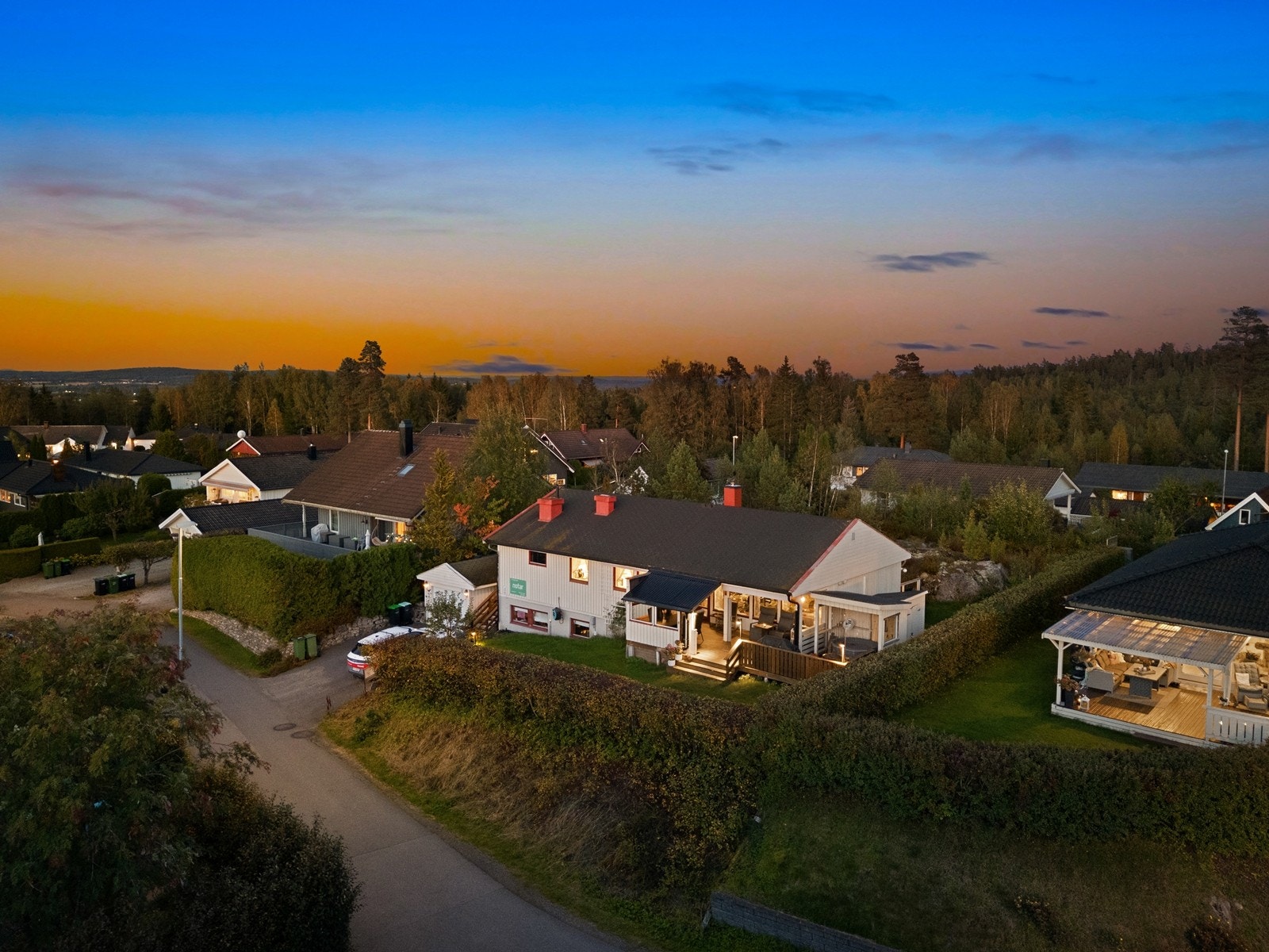 Tomten består av asfaltert gårdsplass, flat gressplen med terrasser og en fin naturtomt. Galleribilde