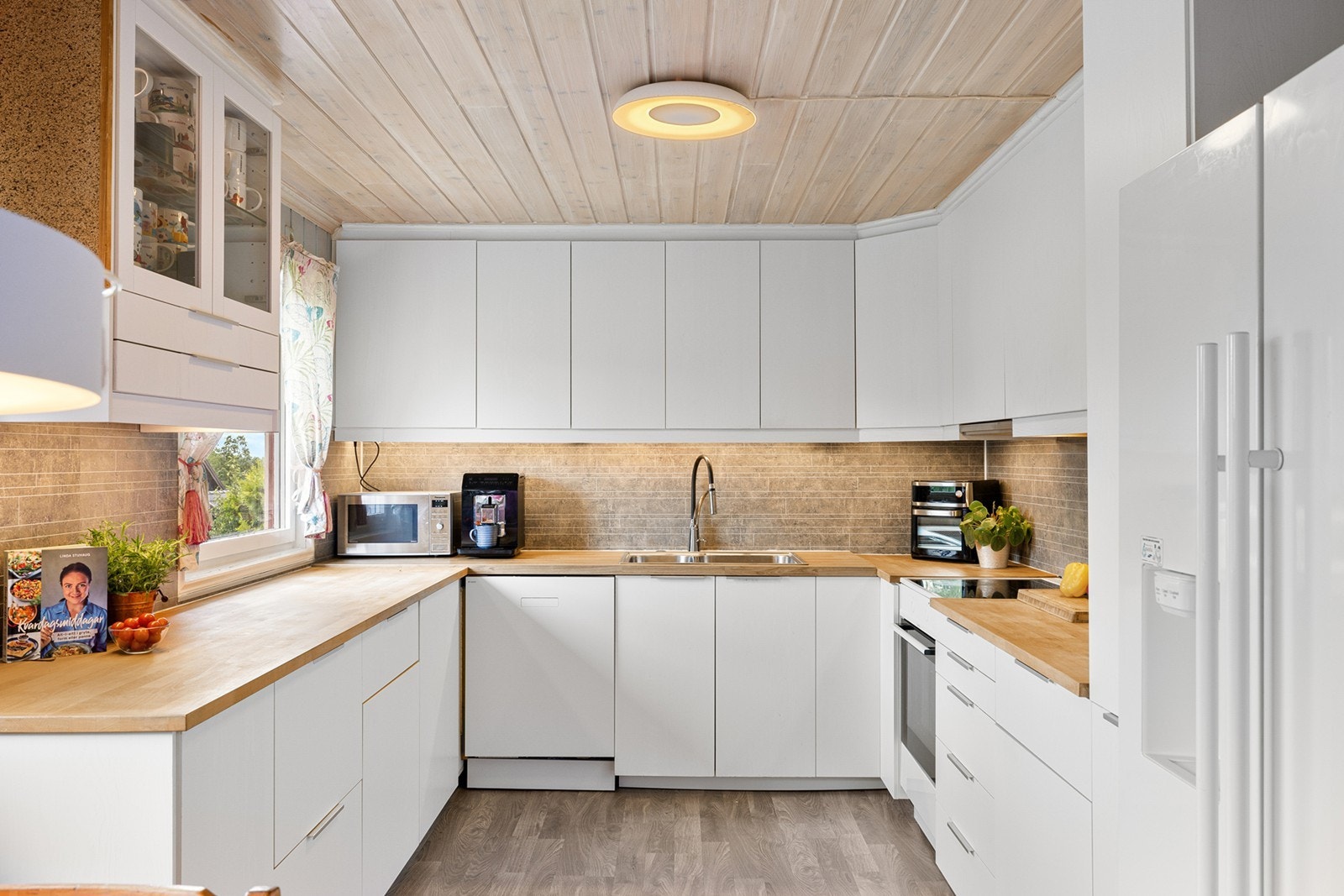 Innredningen er tidsriktig og det er rikelig med skap- og skuffeplass. Benkeplaten rundt vasken er byttet, og det bemerkes at denne er i laminat og resterende i tre. Galleribilde