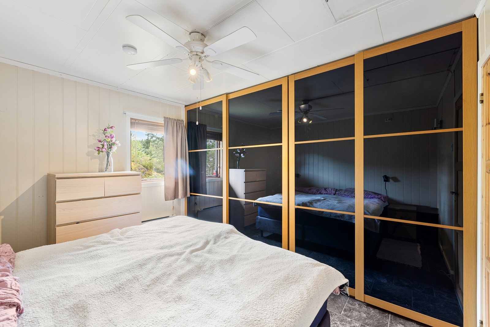 Takhøyt garderobeskap med skyvedører gir rikelig med oppbevaringsplass og bidrar til en luftig romfølelse. Galleribilde