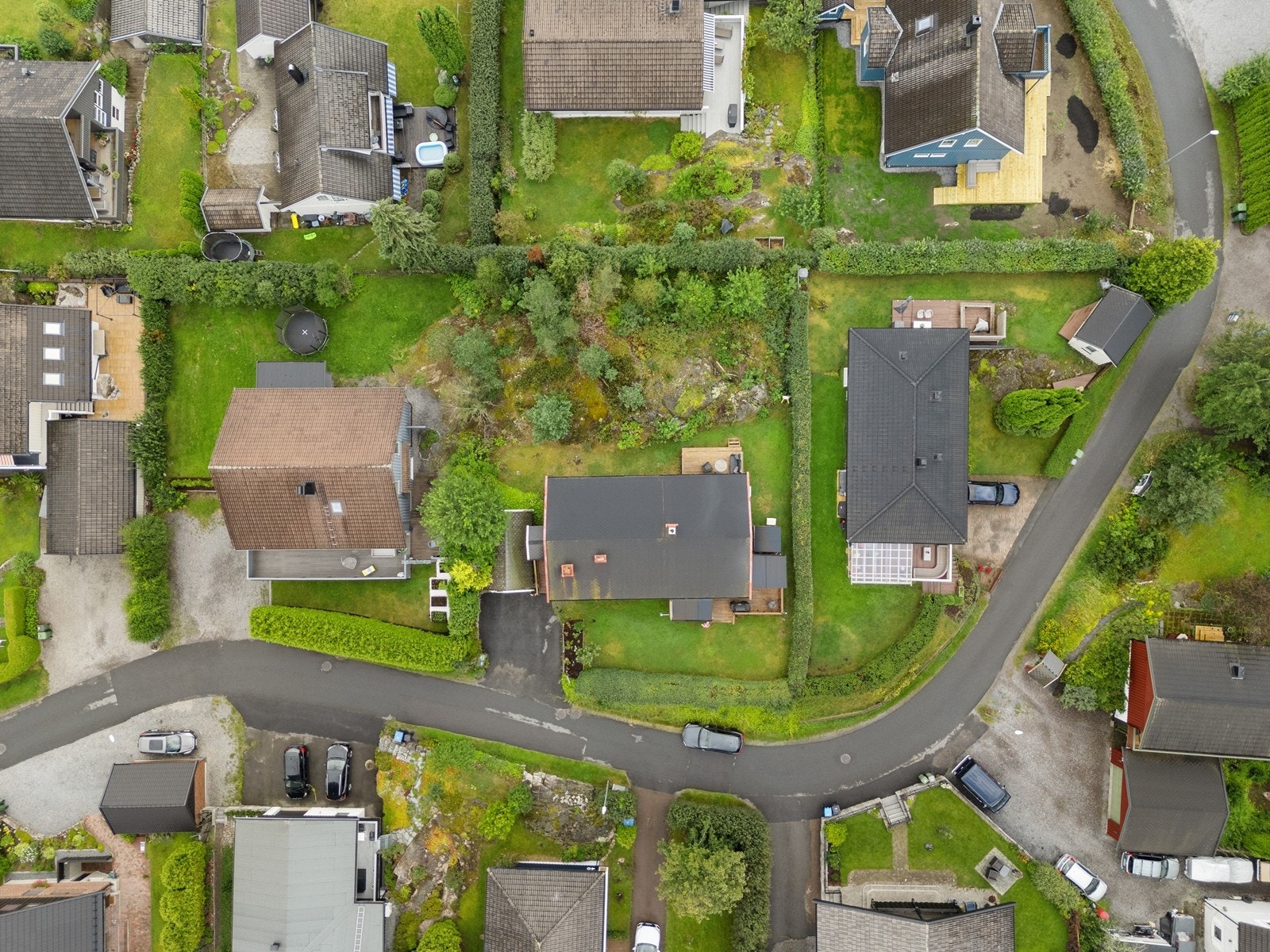 Tomten består av delvis naturtomt og plenområder. Asfaltert gårdsplass. Galleribilde