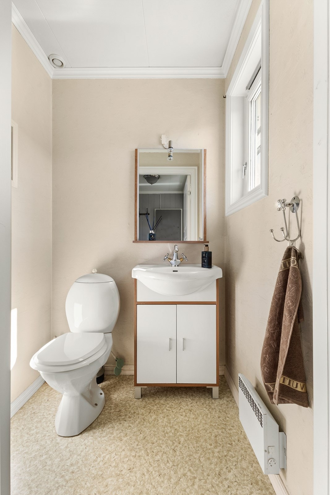 Toalettrommet er praktisk plassert ved vindfanget - ideelt for gjester og hverdagsbruk. Rommet har takess-plater i himling, tapetserte vegger og gulvbelegg Galleribilde