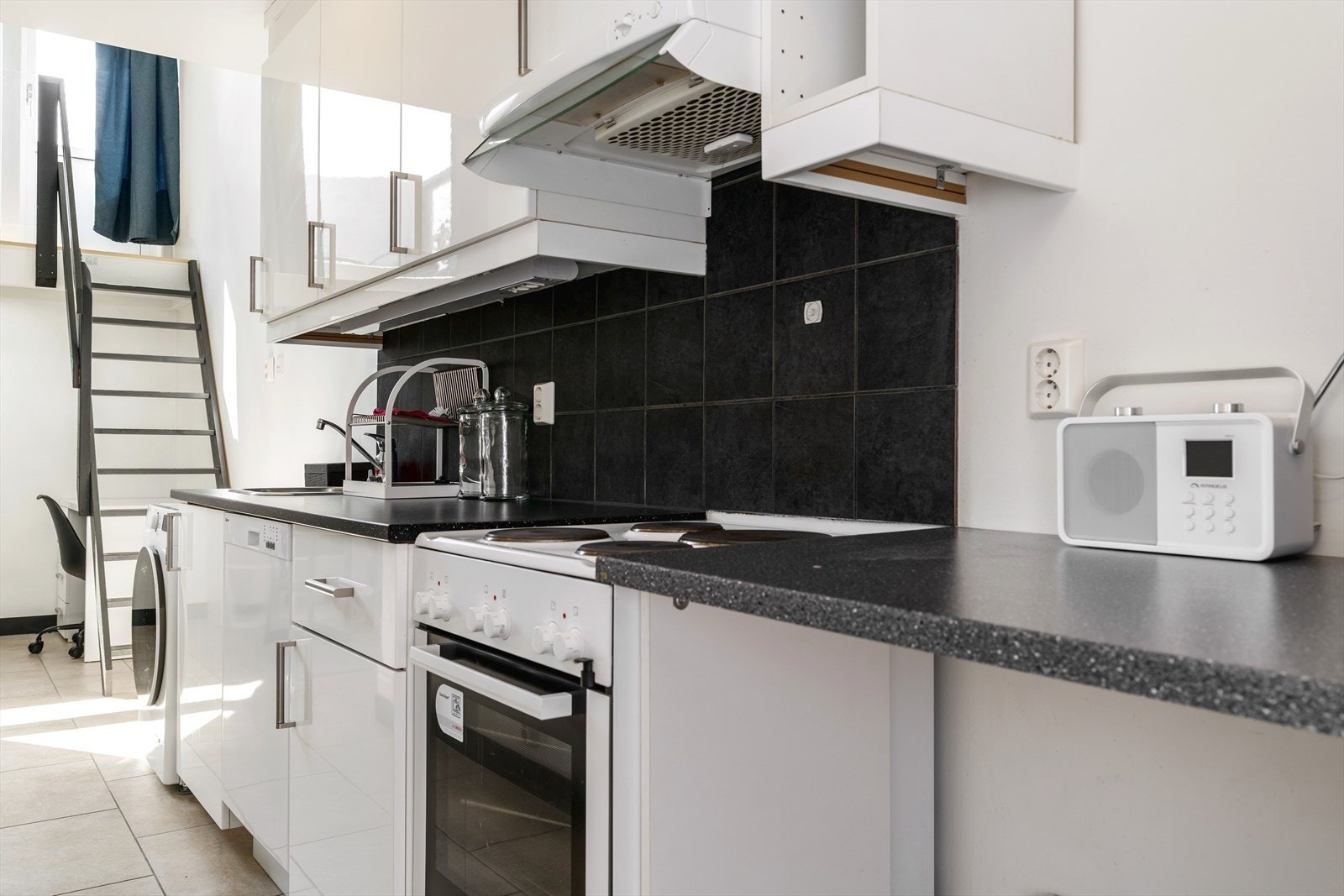 Kjøkkeninnredning med over- og underskap og god benkeplass. Kjøkkenet er utstyrt med integrert oppvaskmaskin, frittstående vaskemaskin, komfyr og kjøl/fryseskap som medfølger leiligheten. Galleribilde