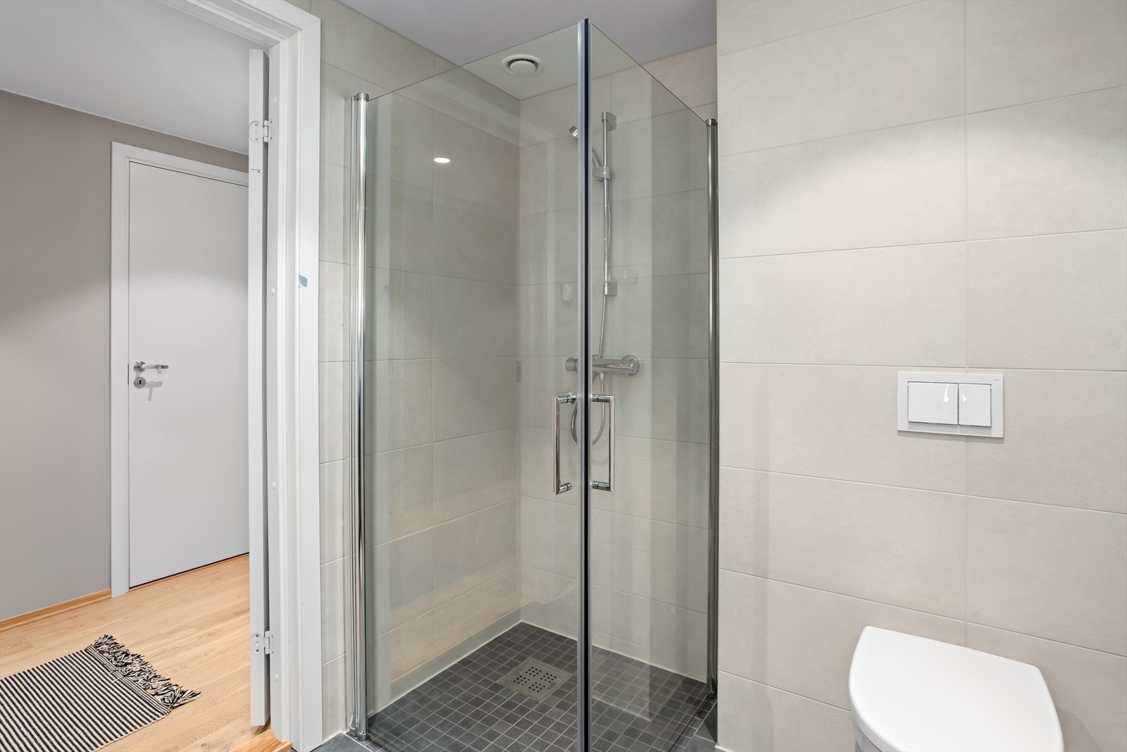 Stort dusjhjørne med glassdører som slår innover når dusjen ikke er i bruk. Galleribilde