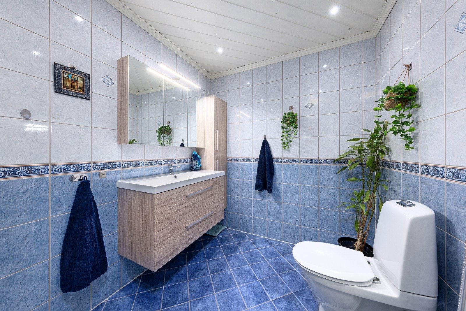 Nyere baderomsinnredning med nedfelt servant/skuffer, porselen toalett og dusjkabinett. Det er elektrisk styrt vifte. Galleribilde