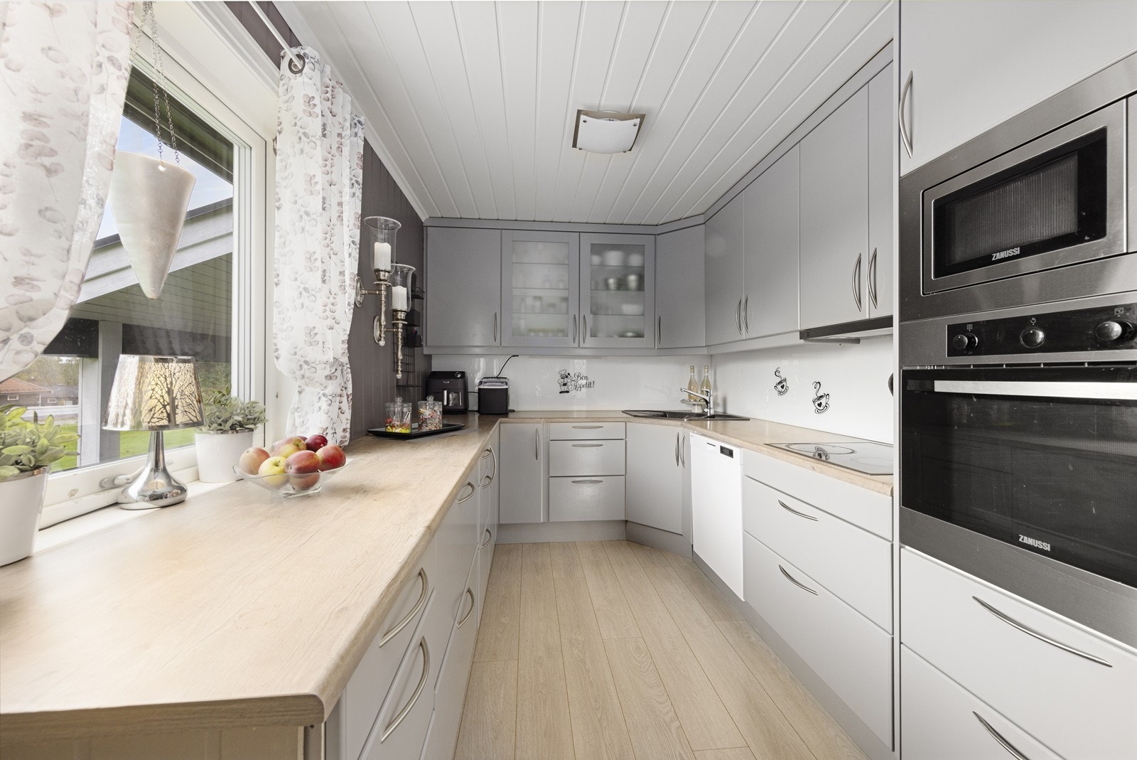 Kjøkkenet har innredning med grå glatte fronter og benkeplaten er av laminat. Galleribilde