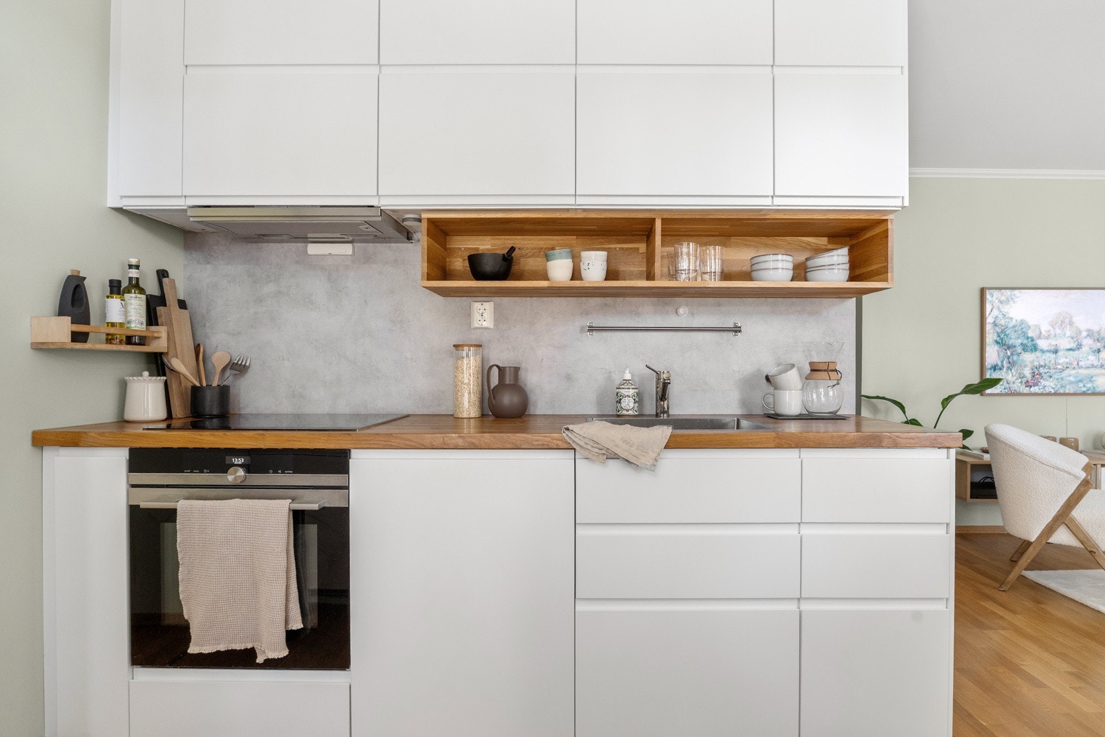 Kjøkkenet er utstyrt med integrerte hvitevarer, inkludert oppvaskmaskin fra Ikea, kjøl/frys fra Bosch, stekeovn og platetopp fra Siemens, samt avtrekksvifte diskret plassert i overskap. Galleribilde