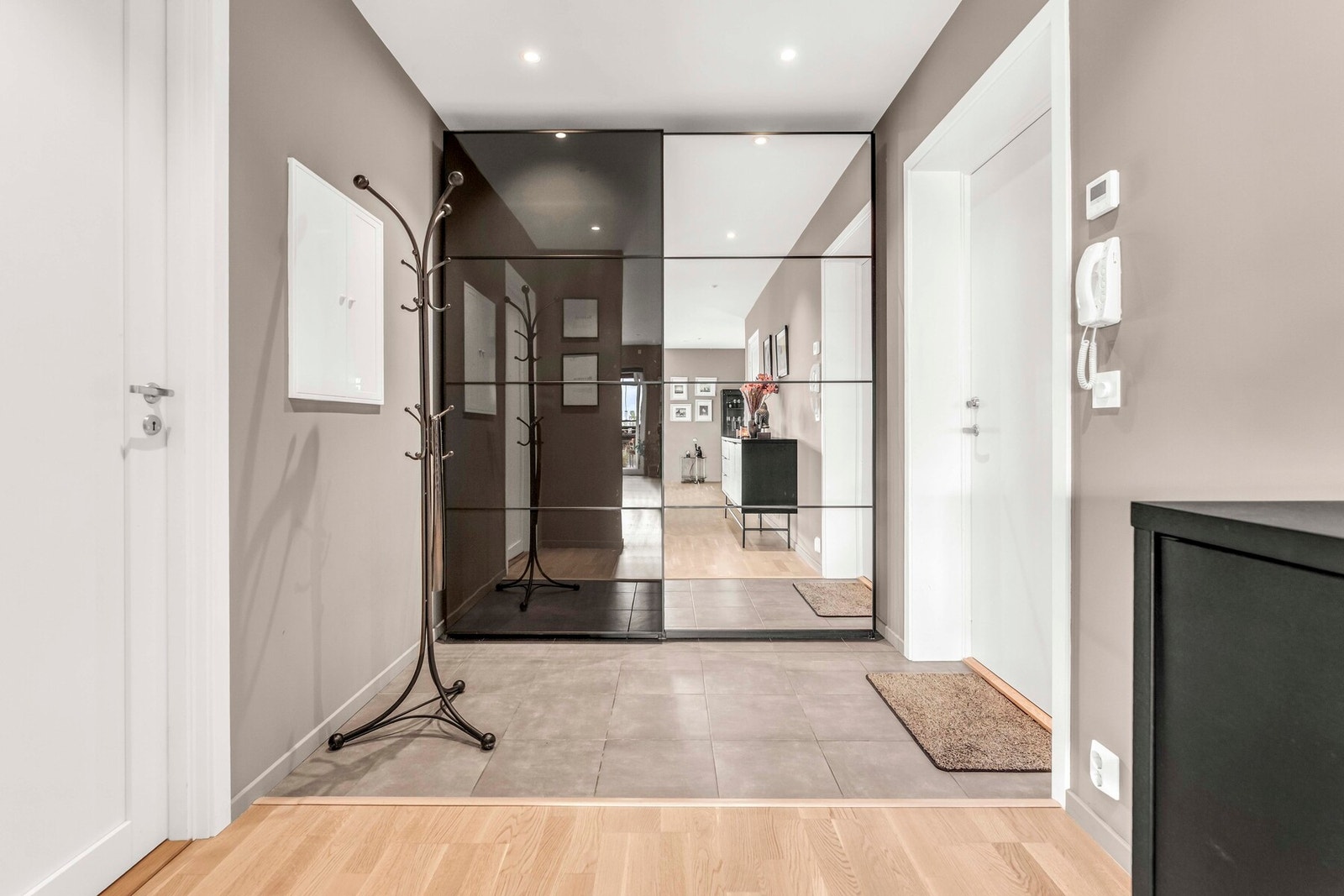 Romslig entre med garderobe og fliser på gulvet Galleribilde