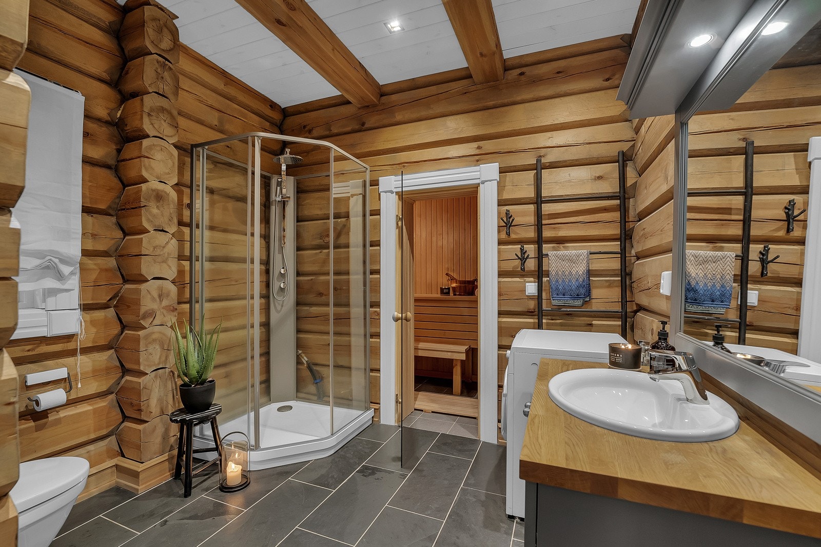 Flott bad som inneholder servant, dusj, toalett og vaskemaskin. Galleribilde