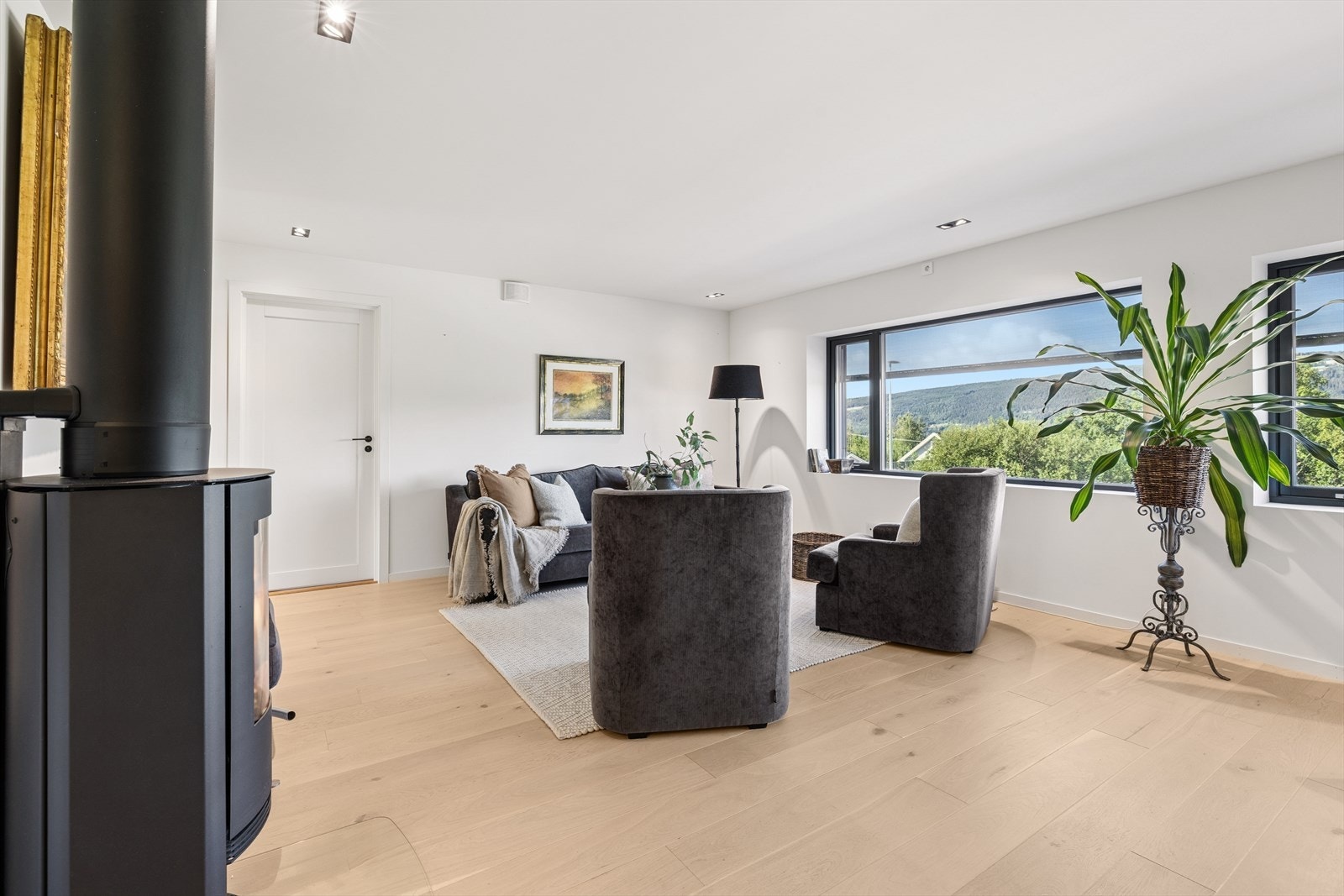 Stuen oppleves som lys og romslig. Overflatene er lysmalte vegger, pen parkett på gulv og lyssatt himling. Galleribilde