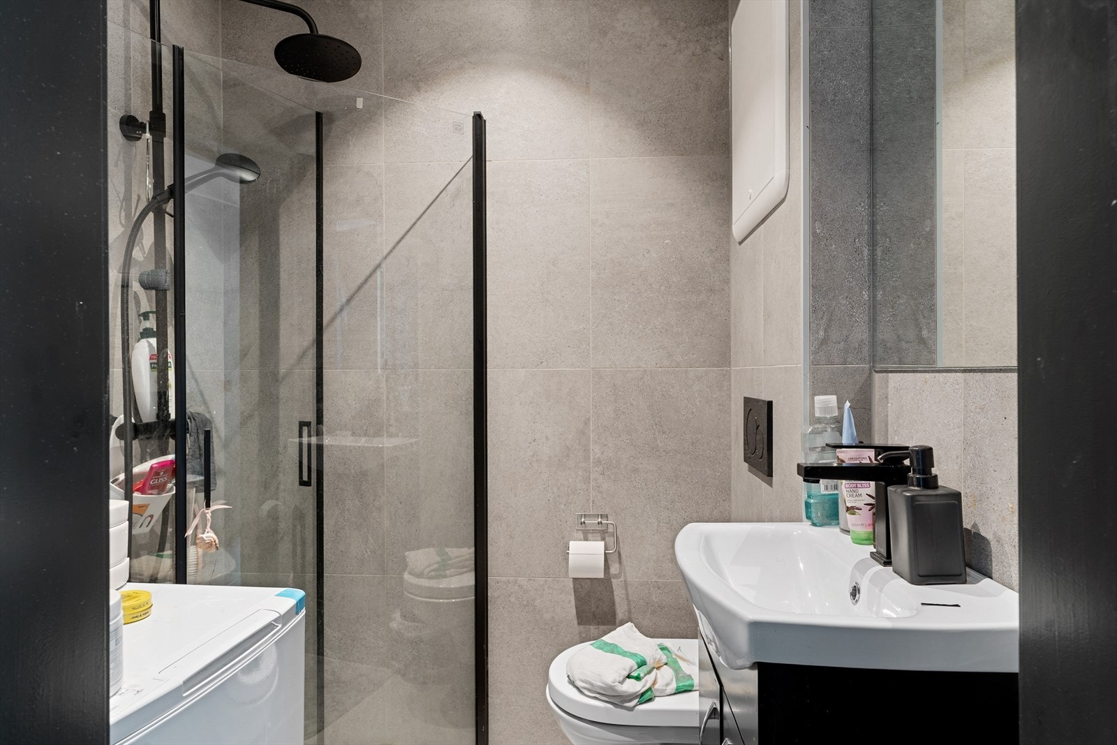 Badet har vegghengt toalett, dusjhjørne med rainshower og innfellbare dusjdører og opplegg for vaskemaskin. Galleribilde