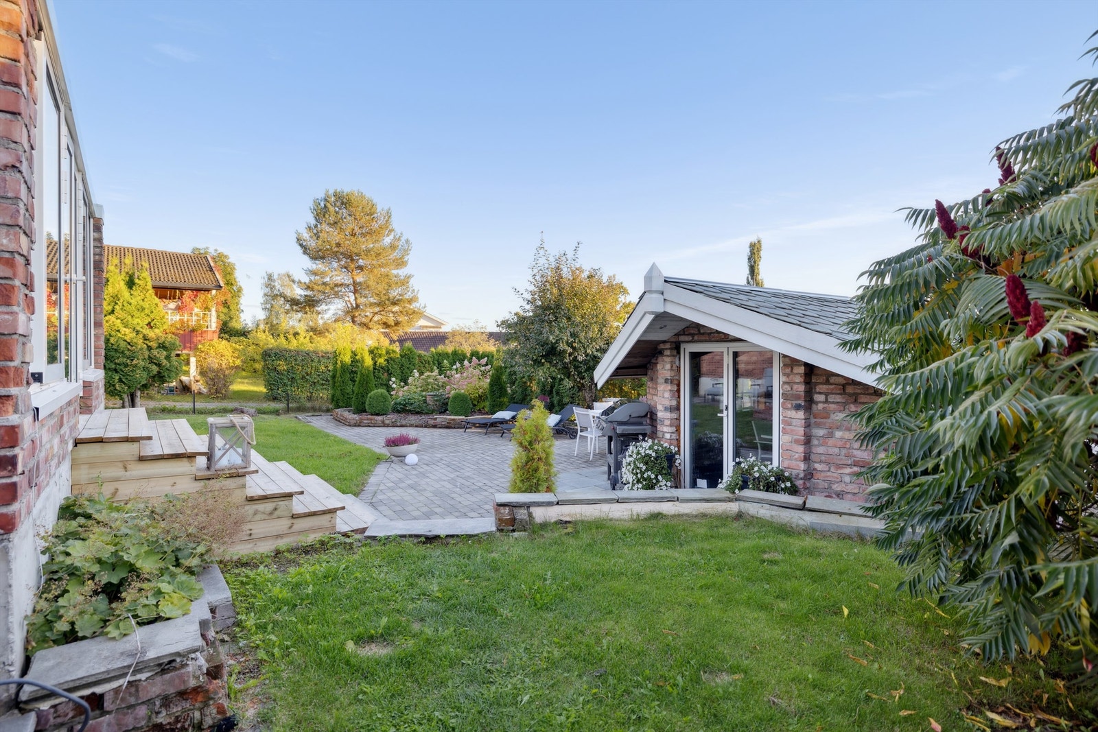 Hagen er skjermet og privat, med en flott kombinasjon av plen og belegningsstein. Galleribilde