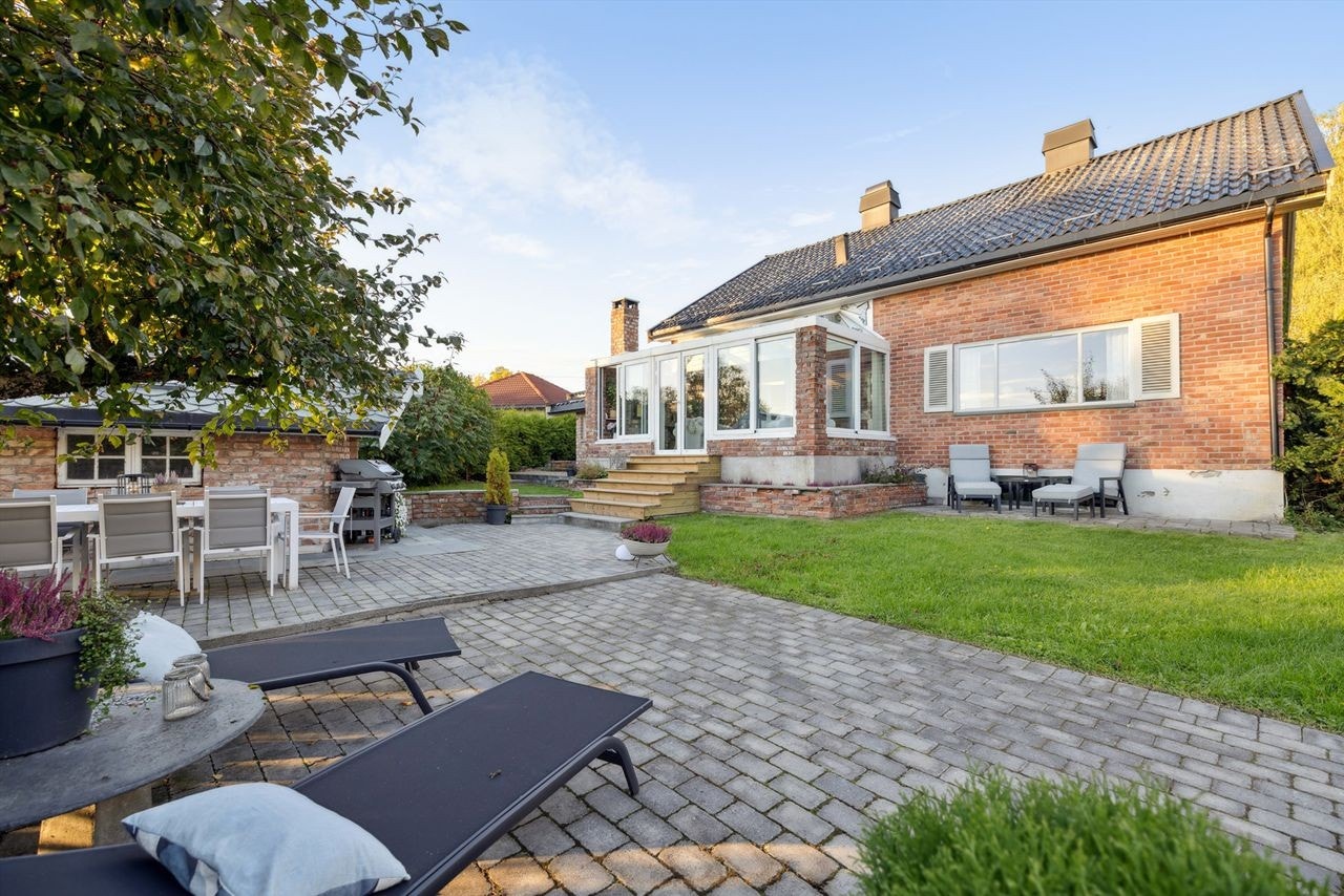 Den 836 m² store tomten er pent opparbeidet med plen, beplantning og flere soner for uteliv. Galleribilde