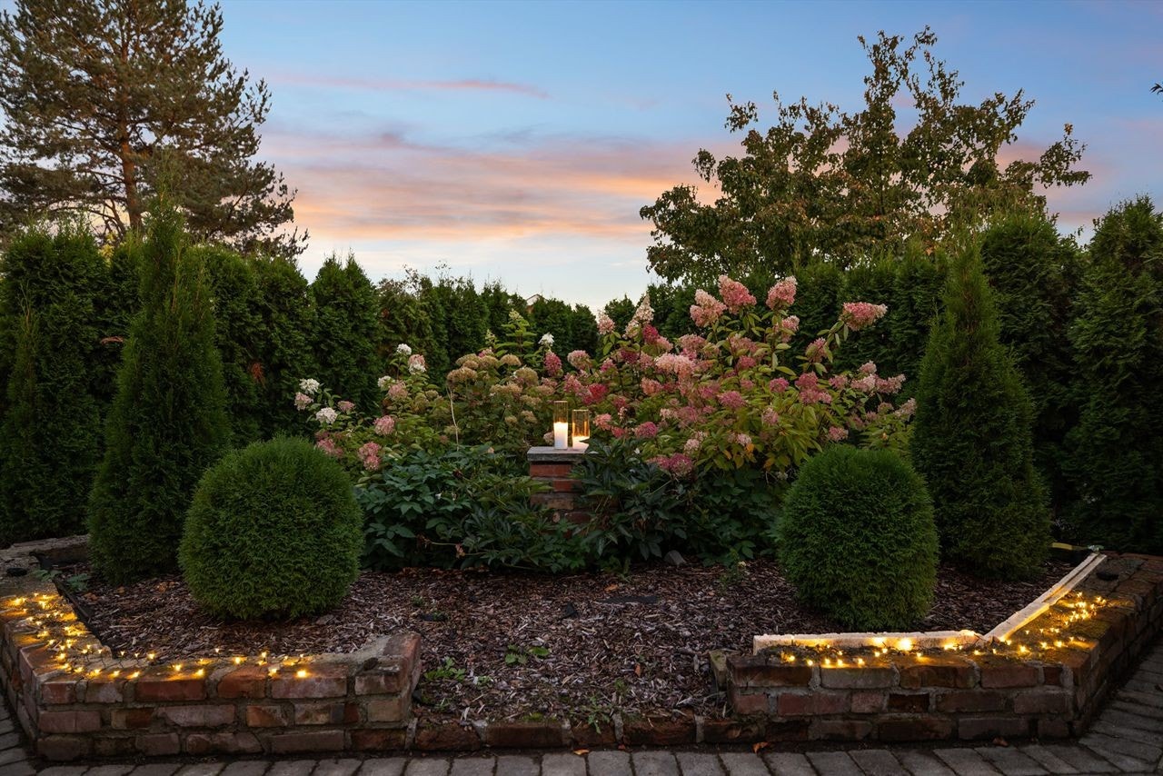 Pent anlagte bed med prydbusker og hekk rammer inn eiendommen på en fin måte. Galleribilde