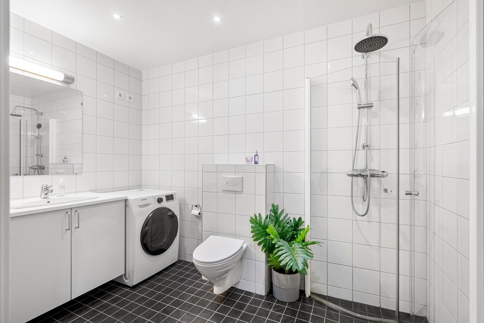 Delikat bad/vaskerom med fliser på gulv og vegg. Galleribilde