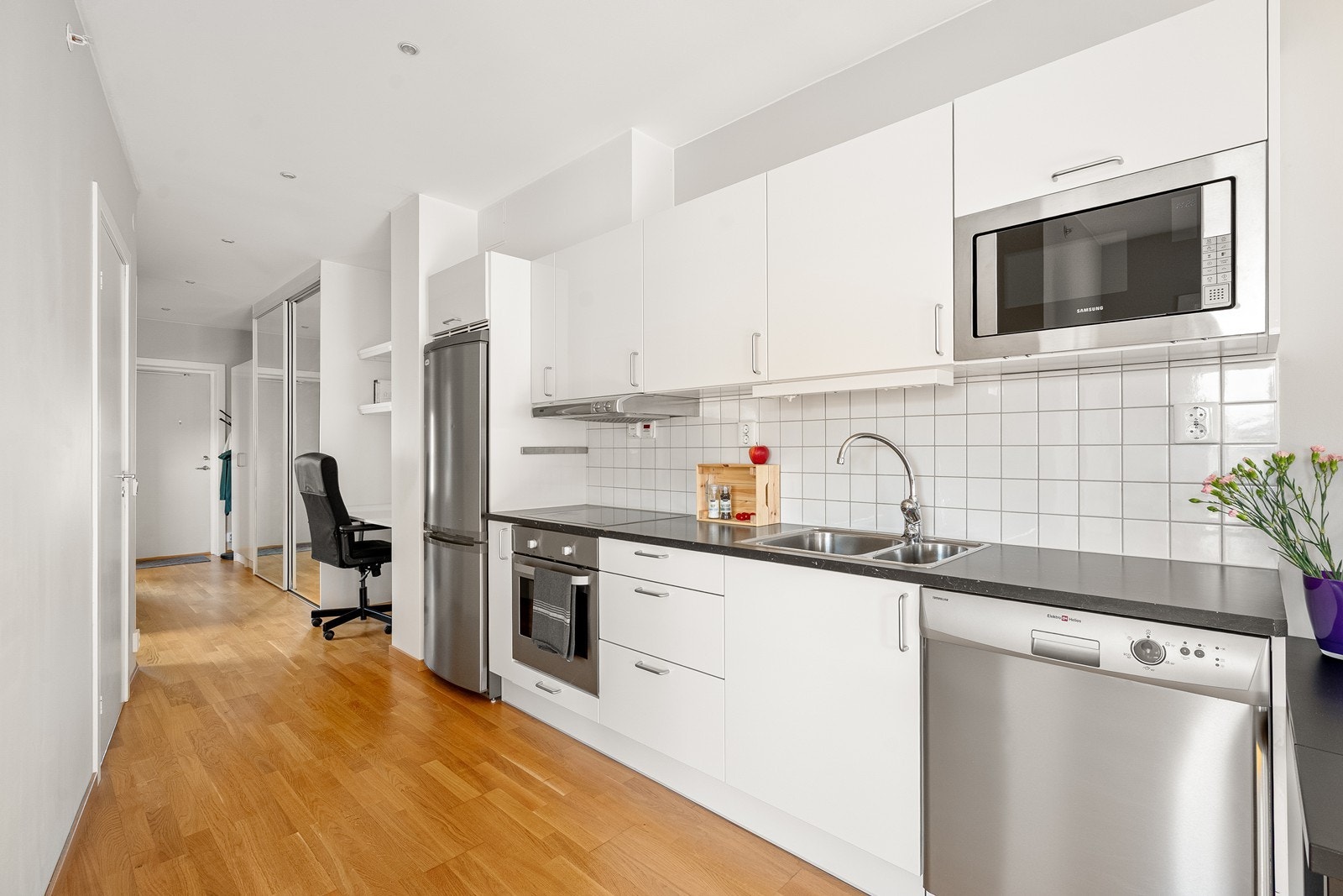 Fin kjøkkeninnredning med slette fronter og laminat benkeplate. Galleribilde