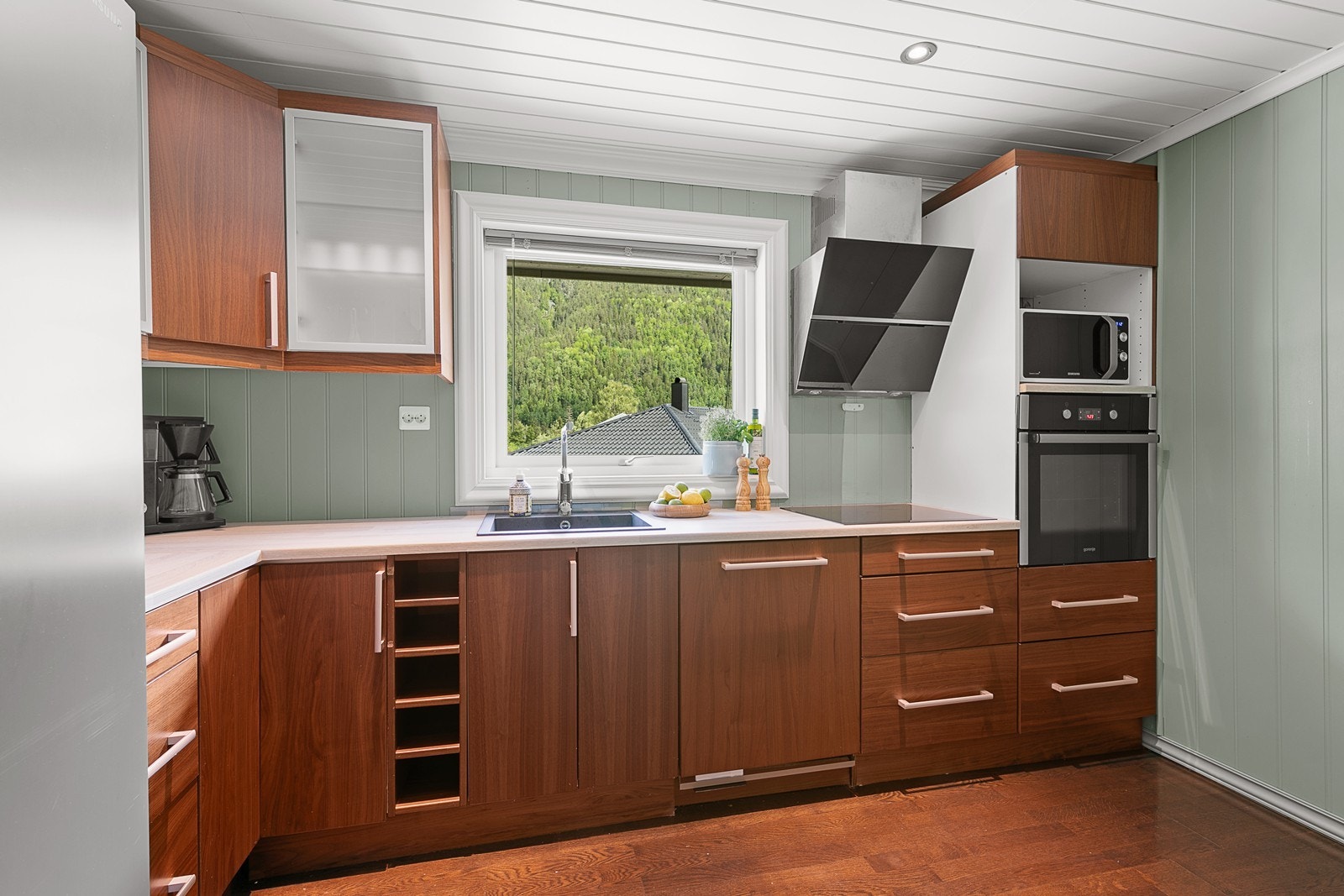 Et pent kjøkken ligger innenfor stuen, med en praktisk innredning montert i 2014. Galleribilde